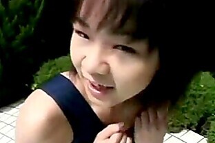 An Asian girl in a swimsuit is sitting at the edge o from